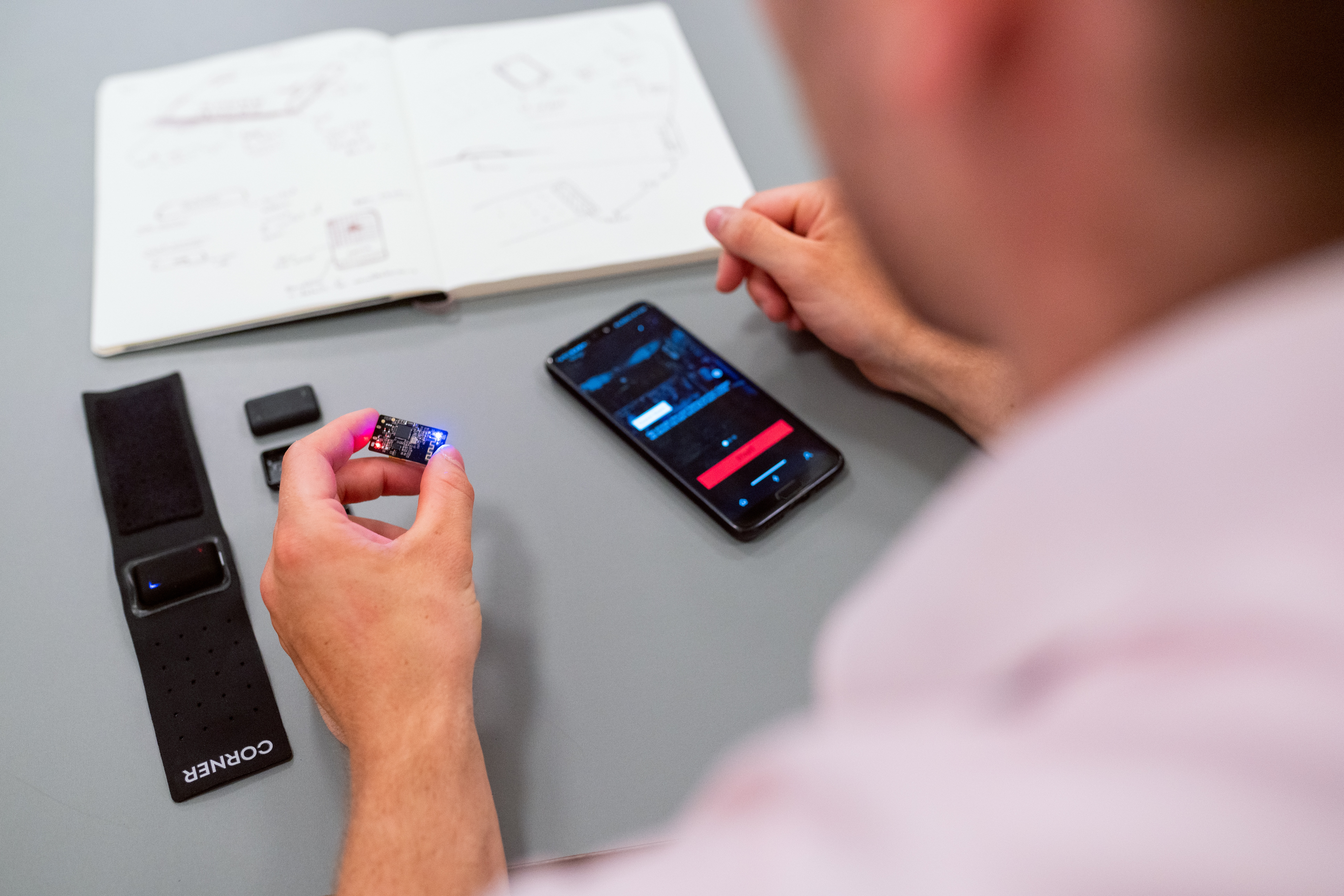 A person holds a computer chip in their left hand and a mobile phone is visible in front of them