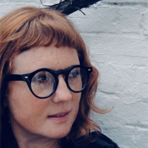 Headshot of Bonnie Lander Johnson with black glasses and a dark top.