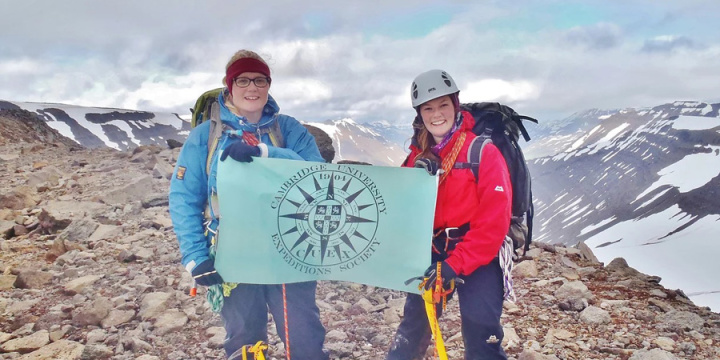 Students hold the Cambridge University Expeditions Society flag