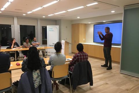 A seminar room with people listening to a person talk