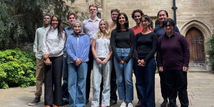The 2025 interns posing for a group photo outside a collegiate building