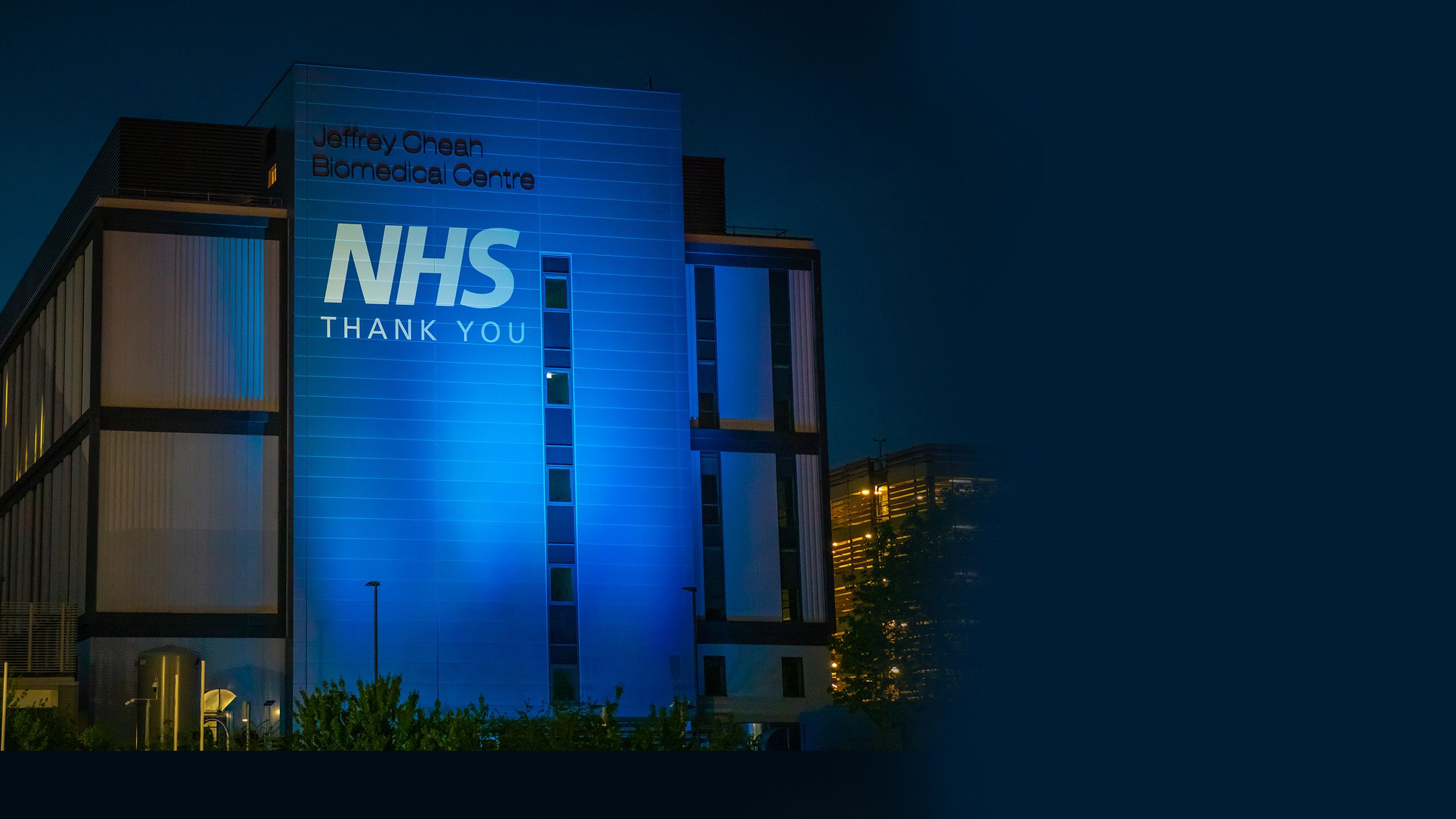 The Jeffrey Cheah Biomedical Centre, lit up in tribute to NHS staff in April 2020
