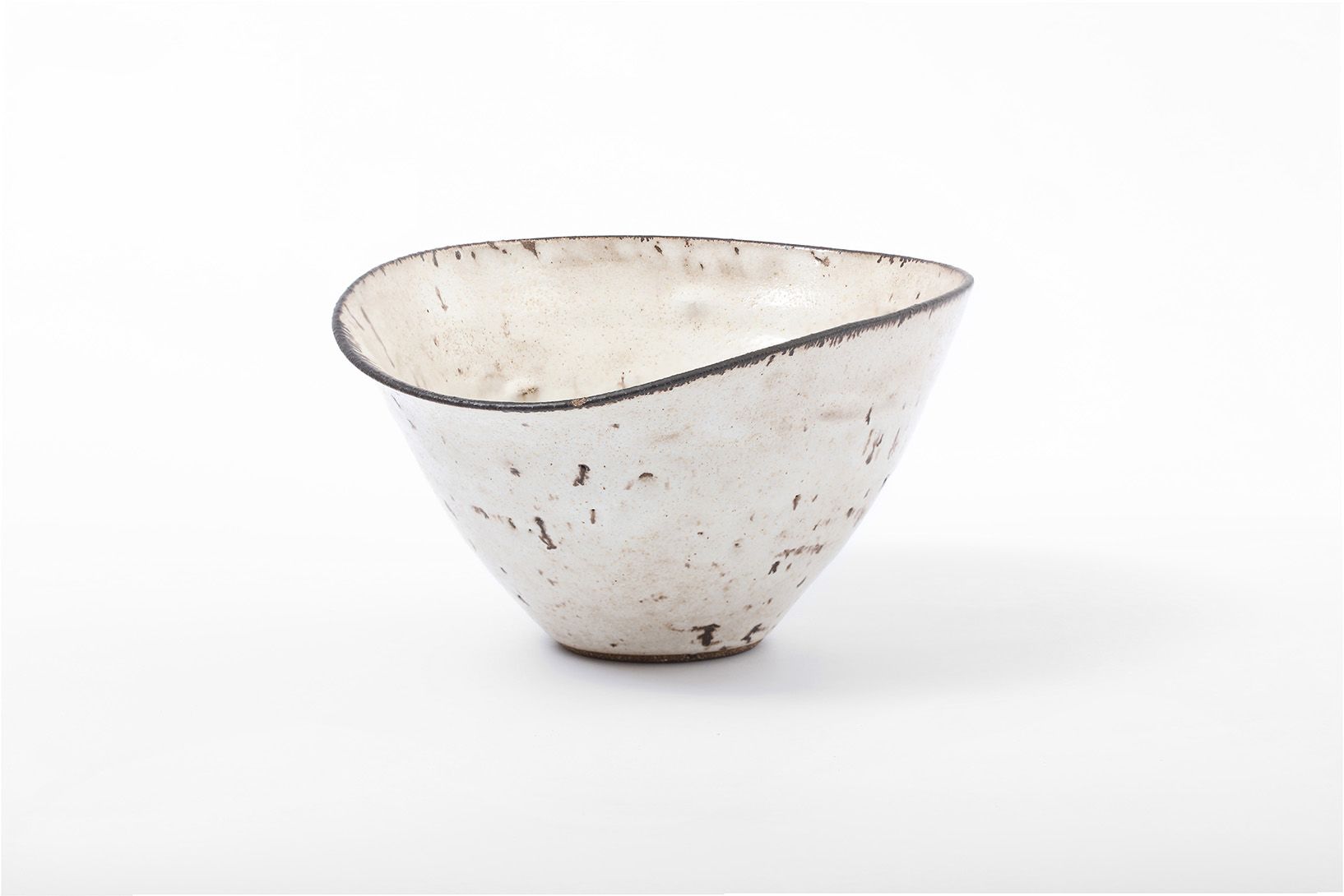 A sculptural white ceramic bowl with an asymmetric rim and a speckled surface, shown against a plain white background.