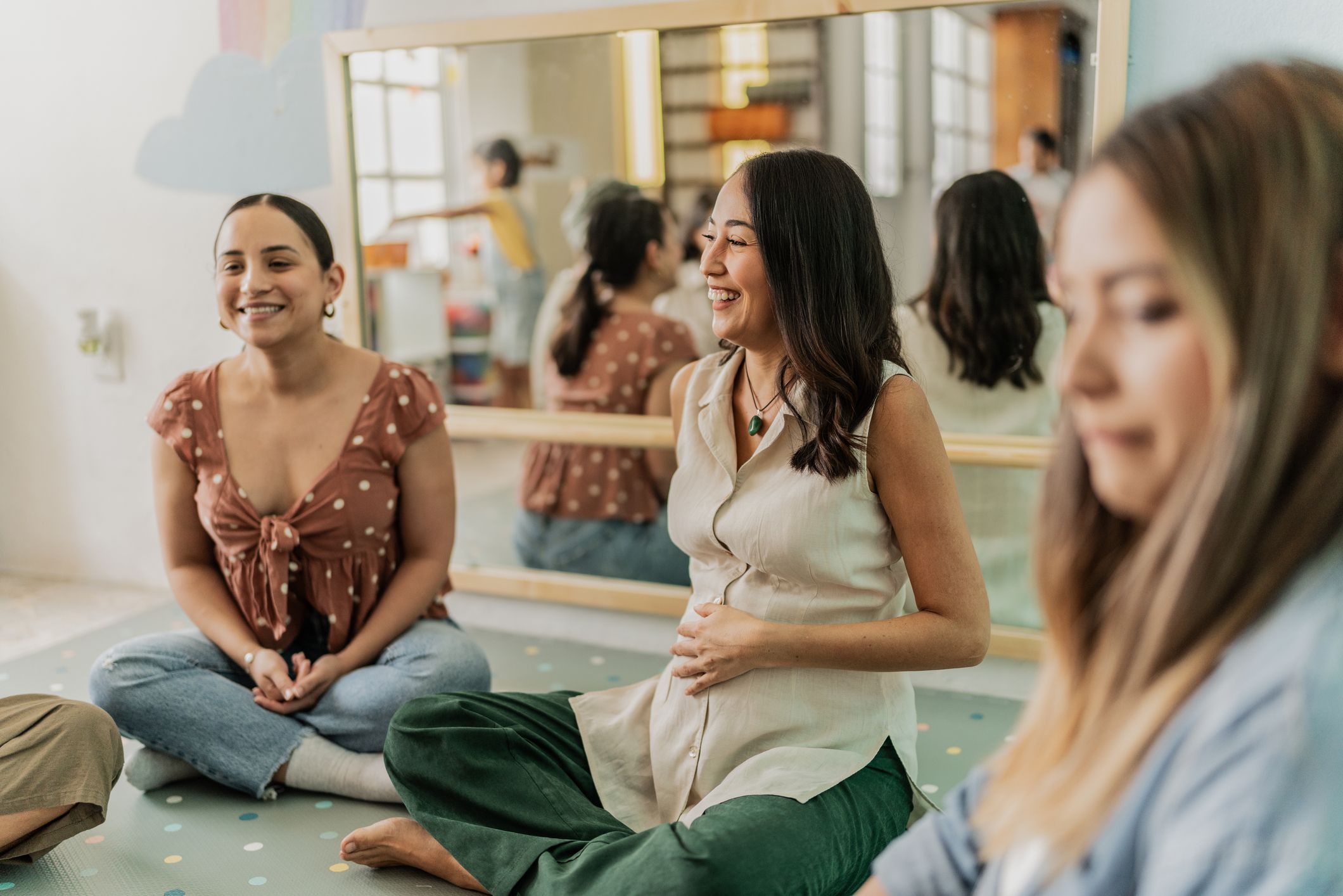 image showing several women at different stages of pregnancy interacting in a support group 