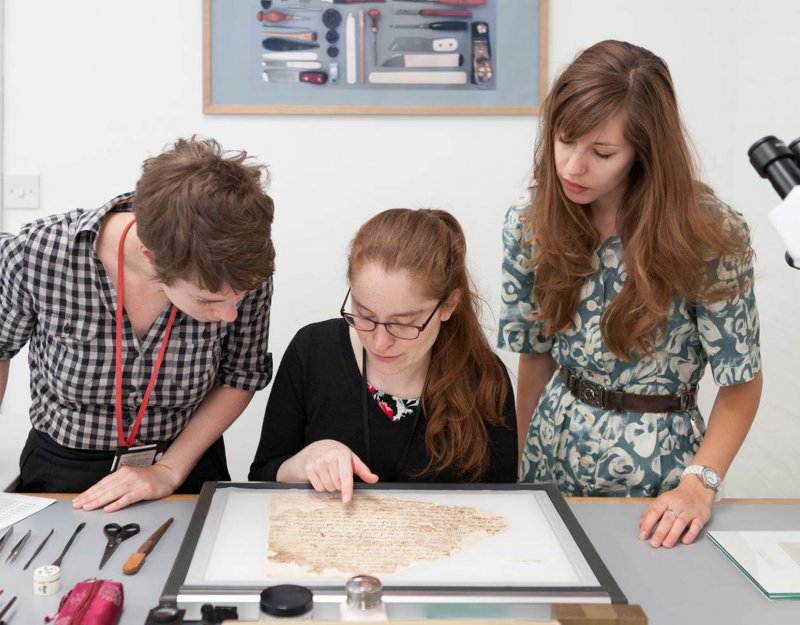 Conservators Rebecca Goldie, Mary French, and Emma Nichols examine a Lewis-Gibson fragment