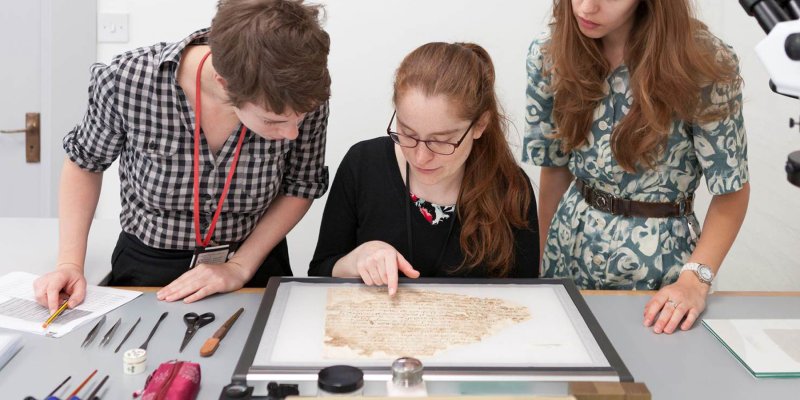 Conservators Rebecca Goldie, Mary French, and Emma Nichols examine a Lewis-Gibson fragment