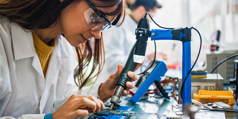 Two people working on circuit boards in an office