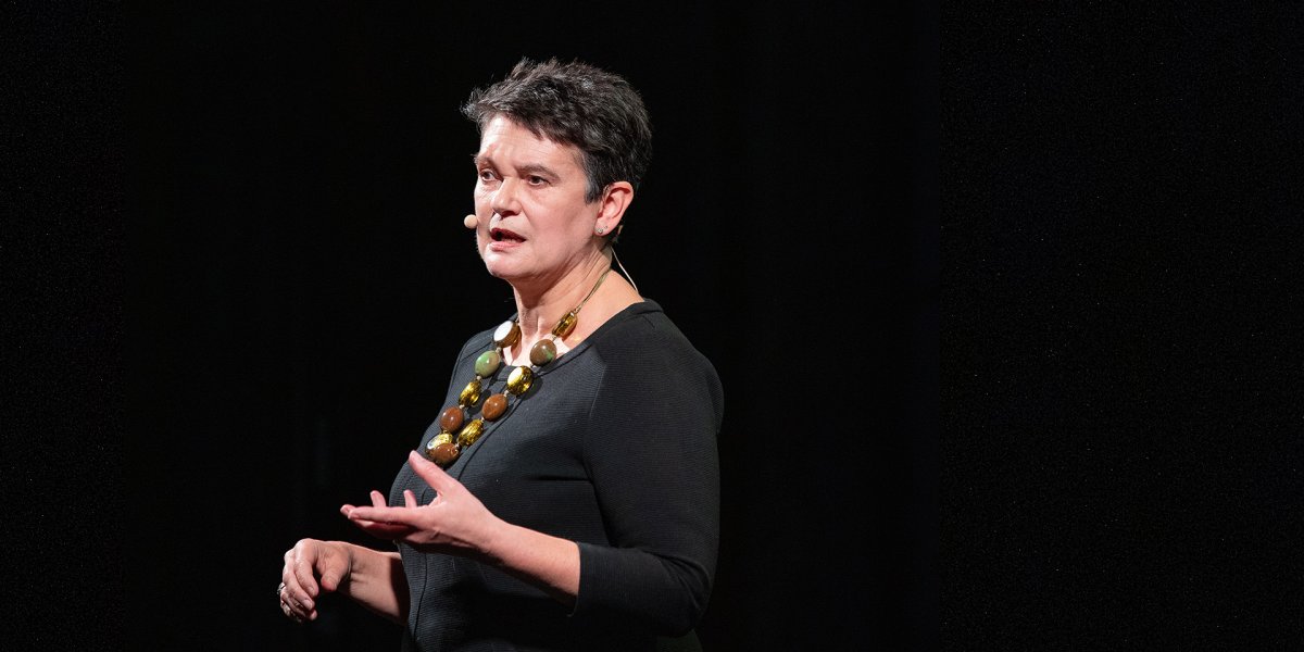 Professor Diane Coyle standing on a stage speaking