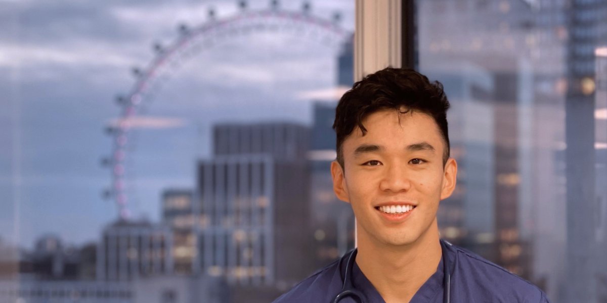 Brian Wang in front of a window with the London Eye in the distance