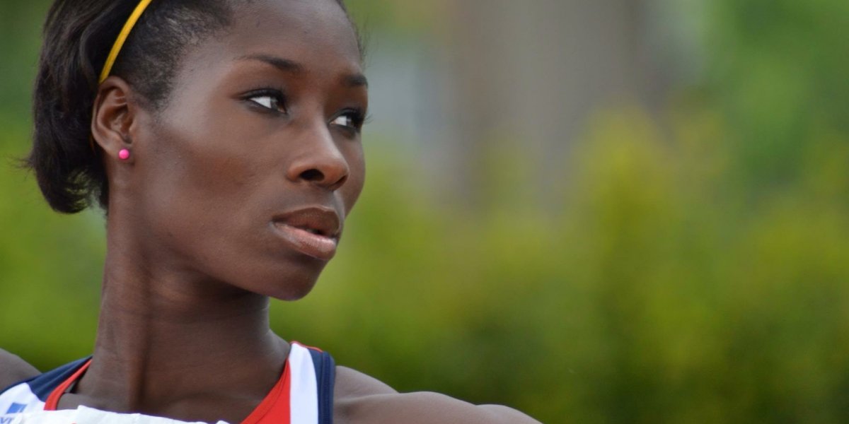 Phyllis Agbo dressed in Team GB kit, holding a javelin and looking to her left.