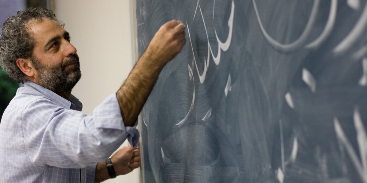 Writing Arabic on a board during a talk