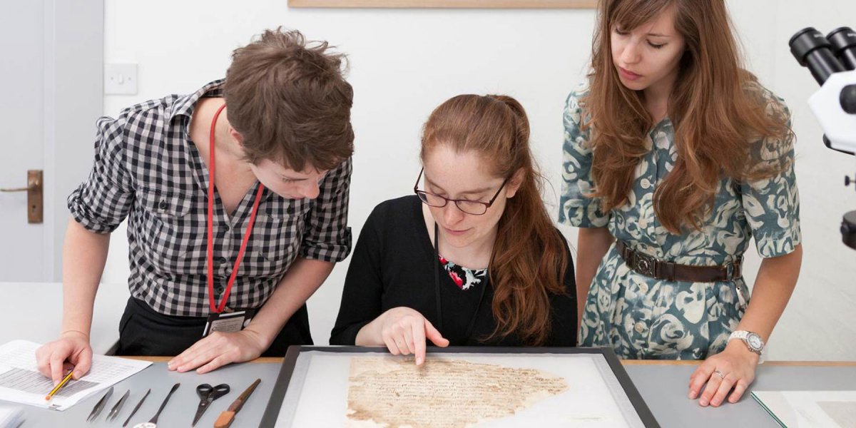 Conservators Rebecca Goldie, Mary French, and Emma Nichols examine a Lewis-Gibson fragment