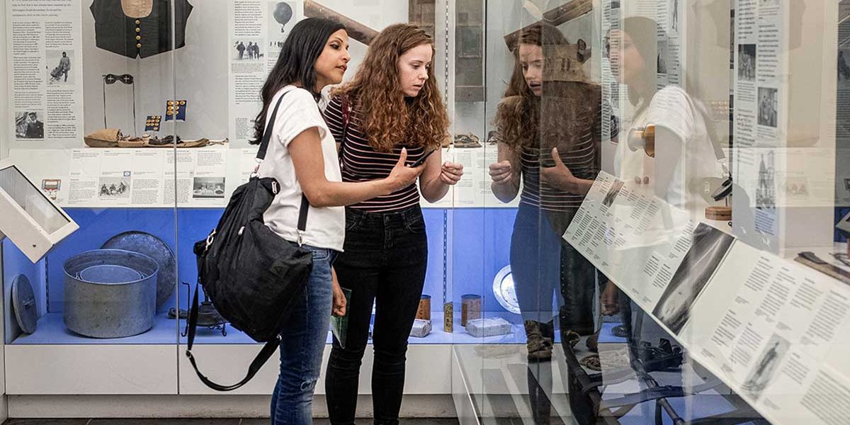 Two females standing in the Scott Polar museum looking at the exhibits